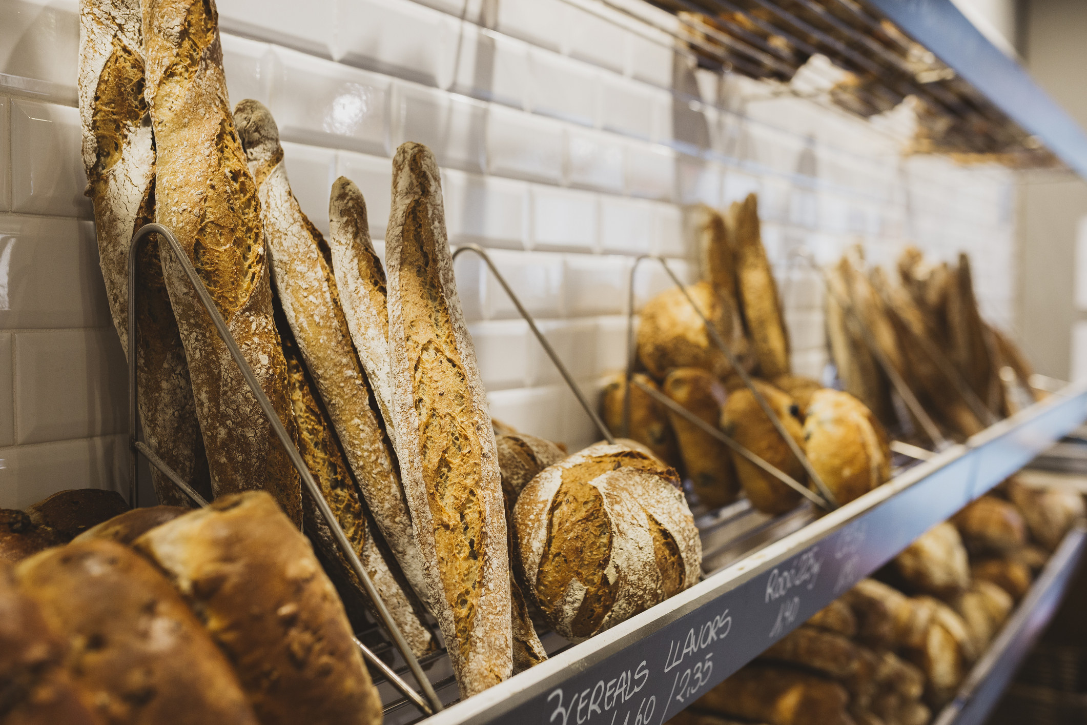 Shelf with rustic bread baguettes at bakery.