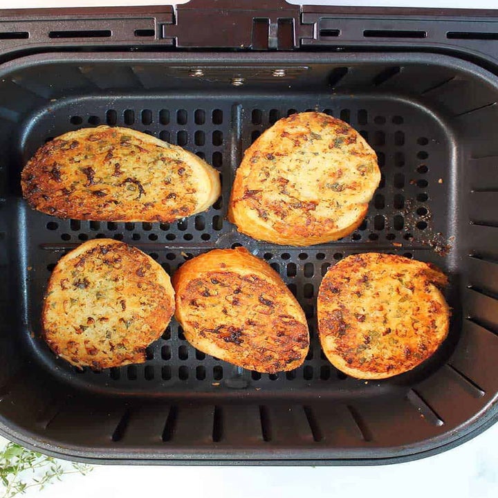 Garlic bread in the air fryer basket.