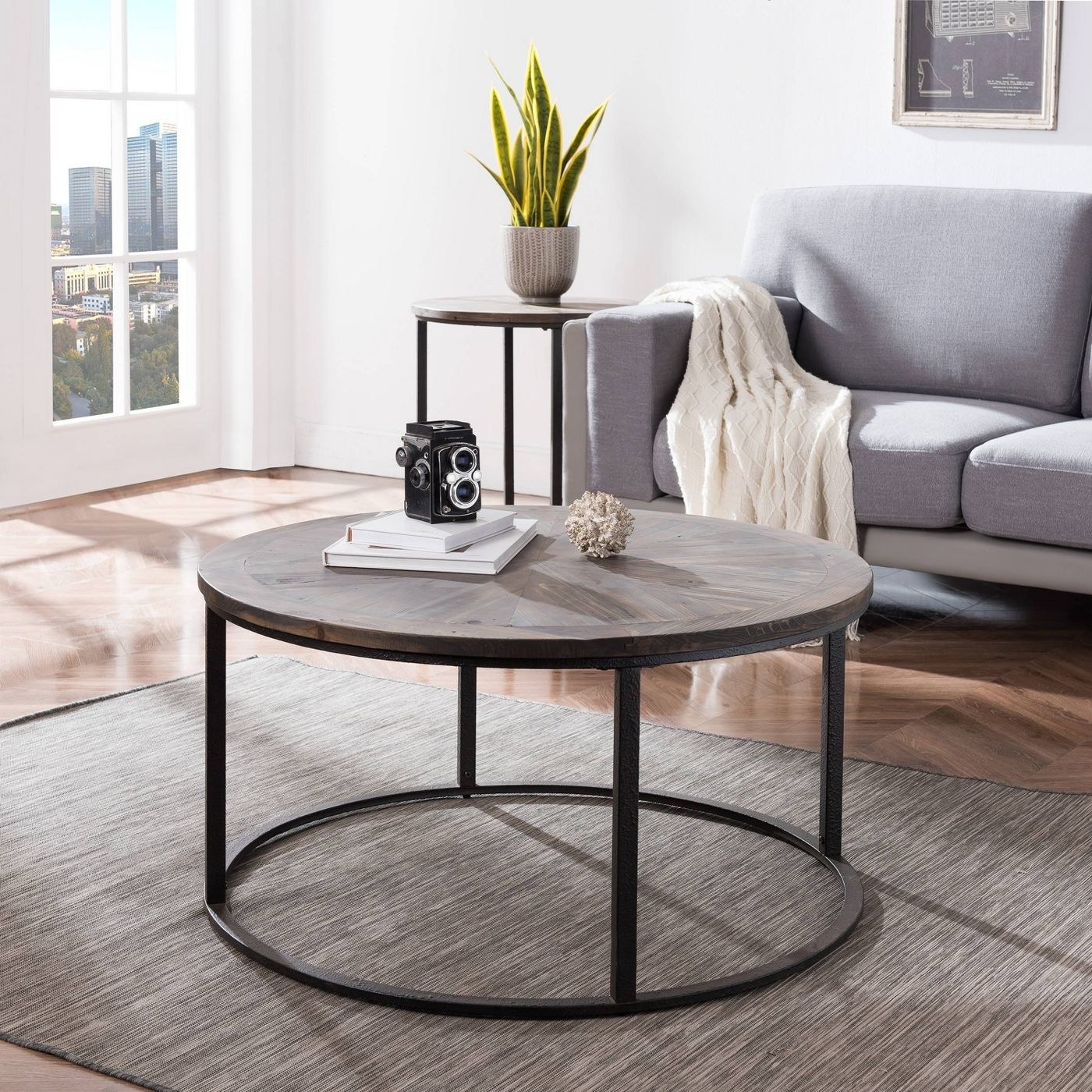 The table with a natural round top and black metal base.