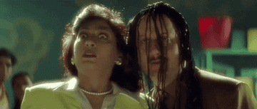 A woman looking surprised. A man with dreadlocks has a bizarre expression on his face