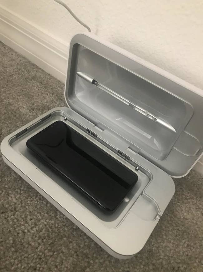 the white rectangular case sitting open with a black iPhone in it