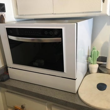 reviewer's white dishwasher with a silver handle and a black-tinted window