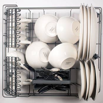 top down view of what the dishwasher rack holding four mugs, four bowls, eight plates, and silverware