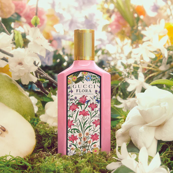 A bottle of perfume lying in grass with flowers around it