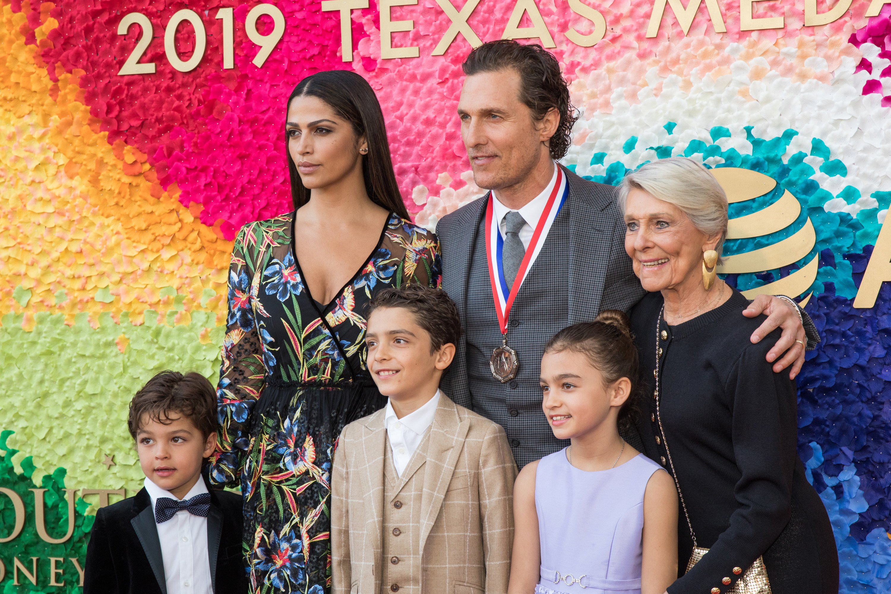 Matthew posing with his family for photos at an event