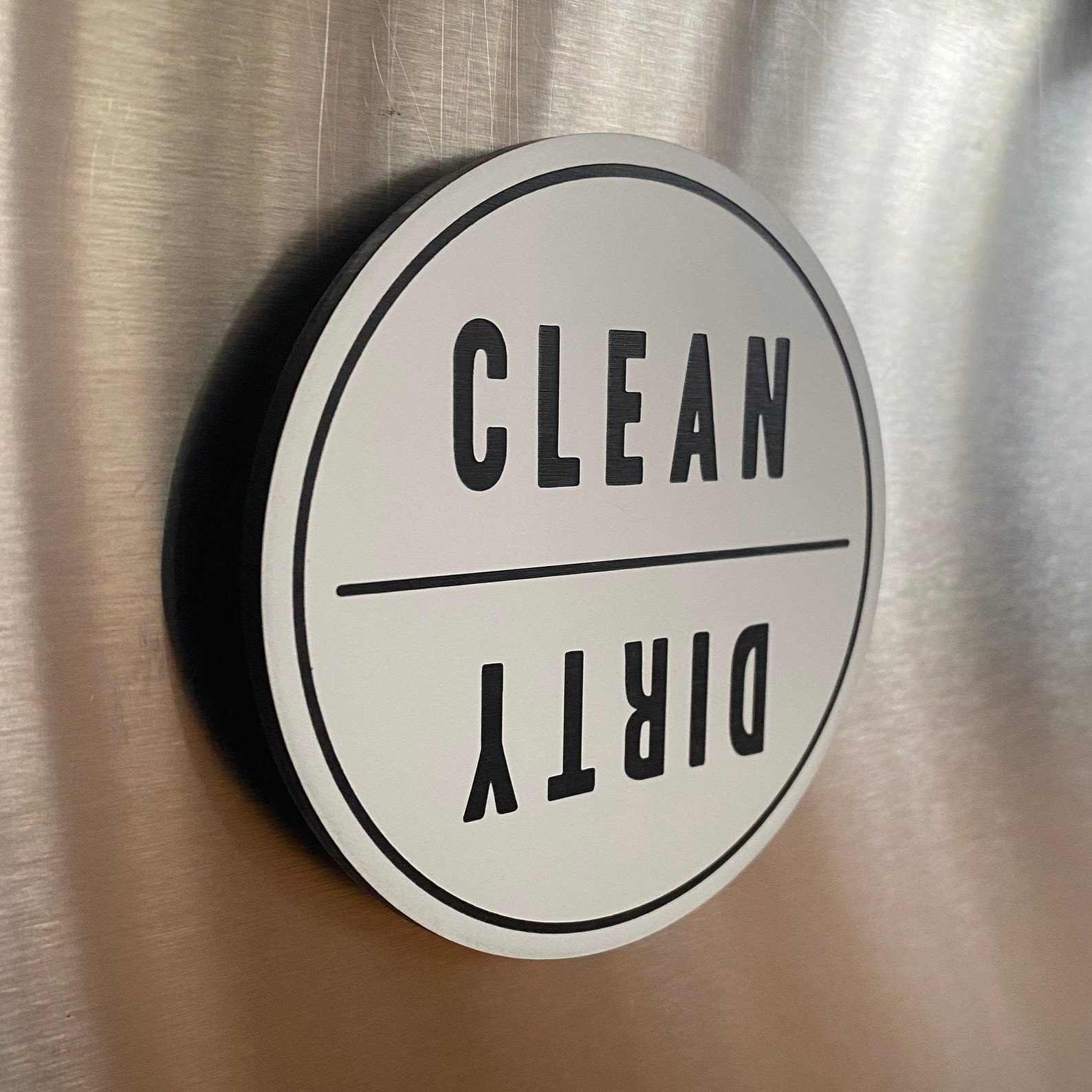 The white and black clean/dirty magnet stuck to a dishwasher