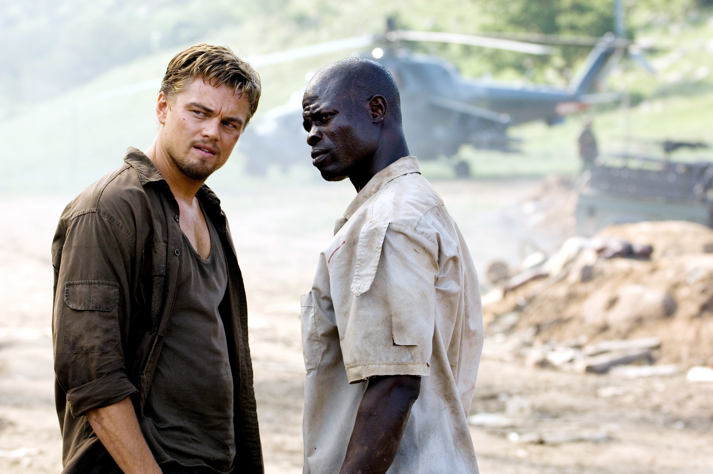 Leonardo DiCaprio and Djimon Hounsou stand by a helicopter