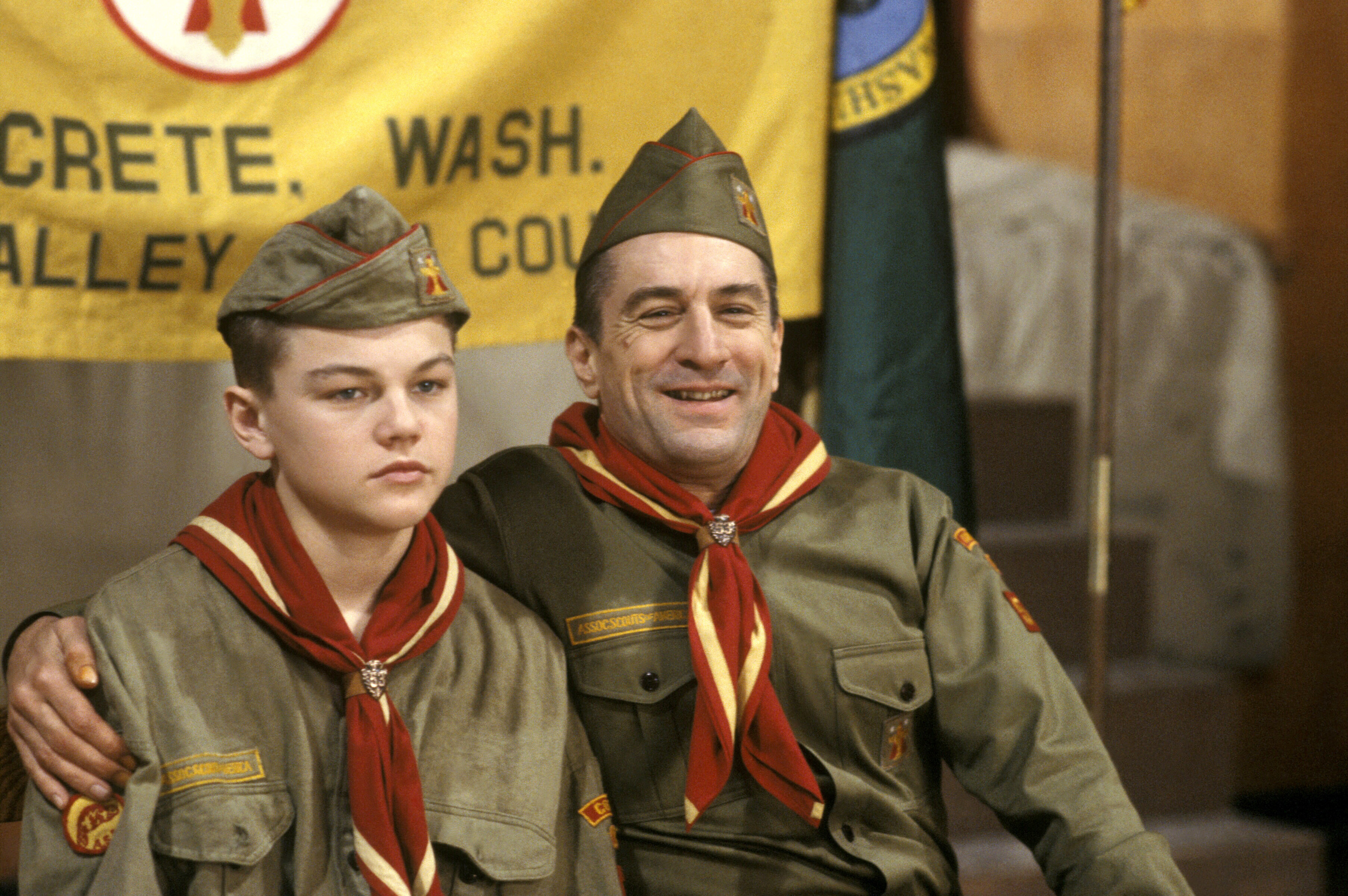 Leonardo DiCaprio and Robert De Niro sit together in Boy Scout uniforms
