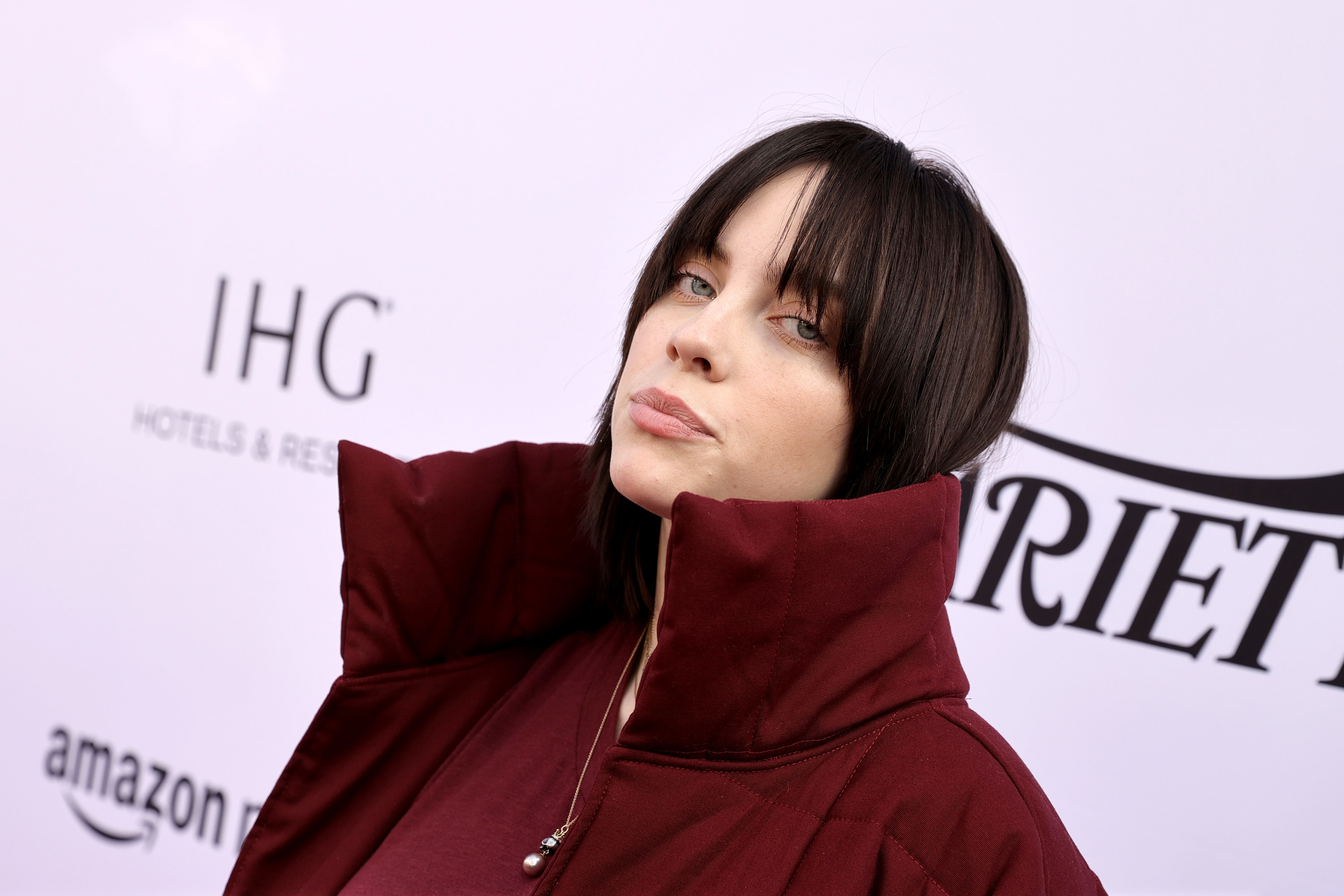 Photo of Billie Eilish in a large red coat