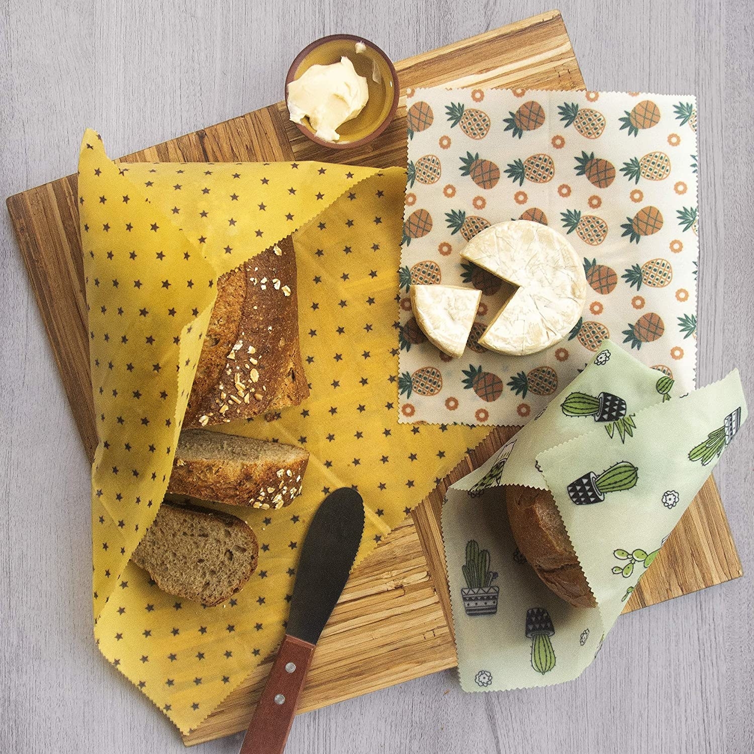 A trio of beeswax wraps covering breads and cheese