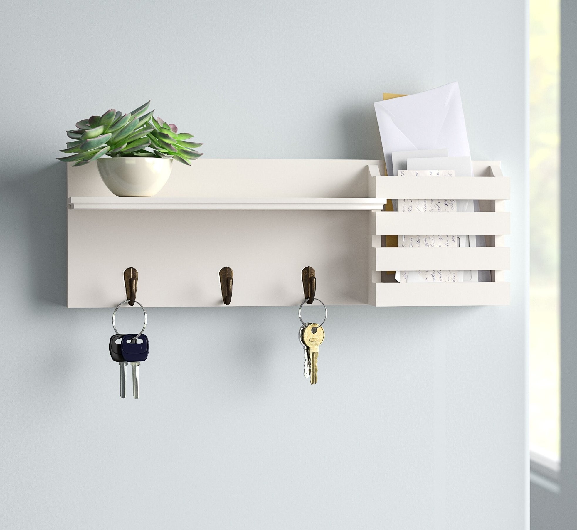The white shelf on a wall holding keys, a succulent, and mail