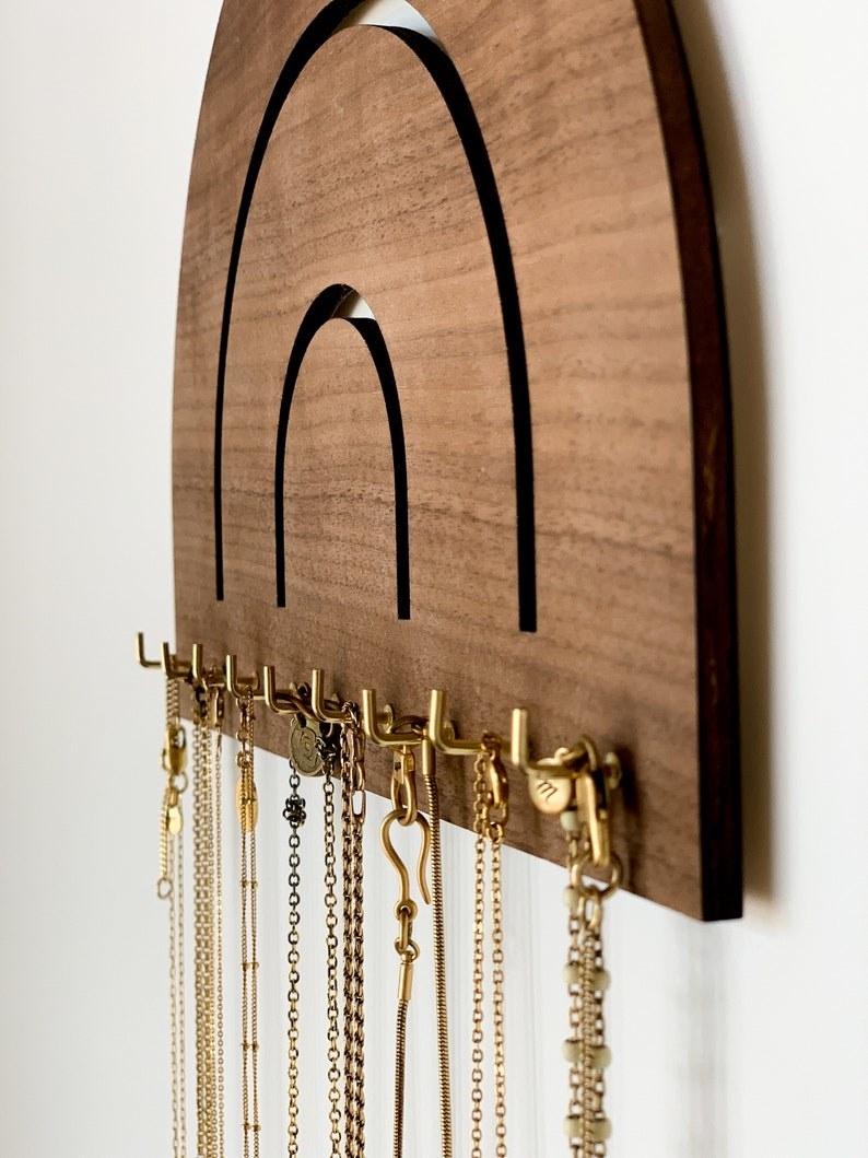 Wall-mounted wooden necklace holder.
