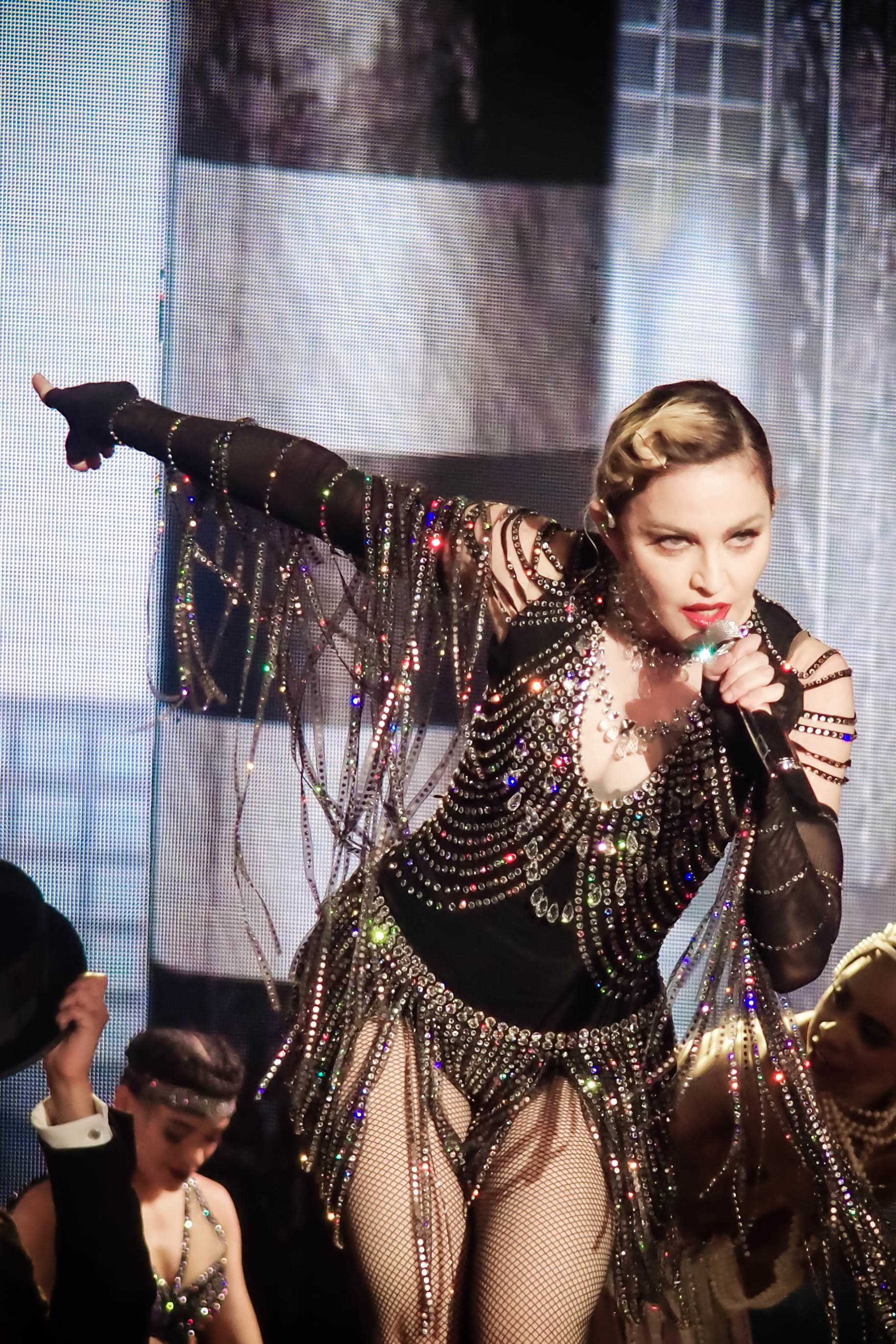 Madonna performing onstage in a bedazzled bodysuit
