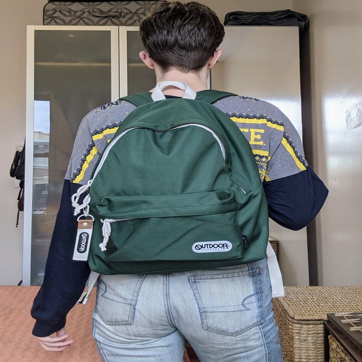 a BuzzFeed writer wearing the backpack in forest green