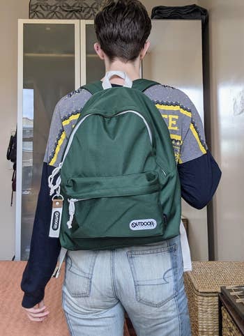 a BuzzFeed writer wearing the backpack in forest green
