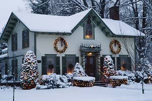 a home covered in snow decorated for christmas