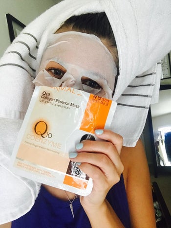 a reviewer wearing the white sheet mask and holding the packaging up to their face