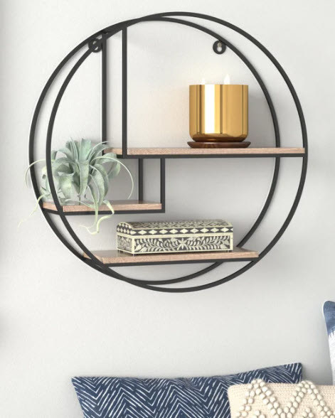 A circular steel hanging shelf with three levels. Mango wood-style shelves organized asymmetrically in the center