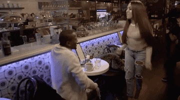 Woman throwing drink at man in a restaurant