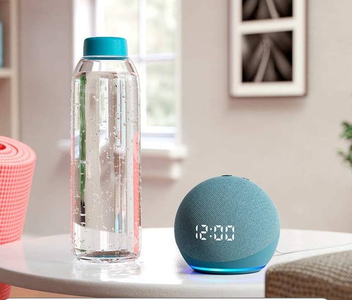 the echo dot speaker next to a full water bottle for scale