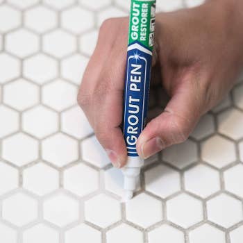 A model using the pen on their grout