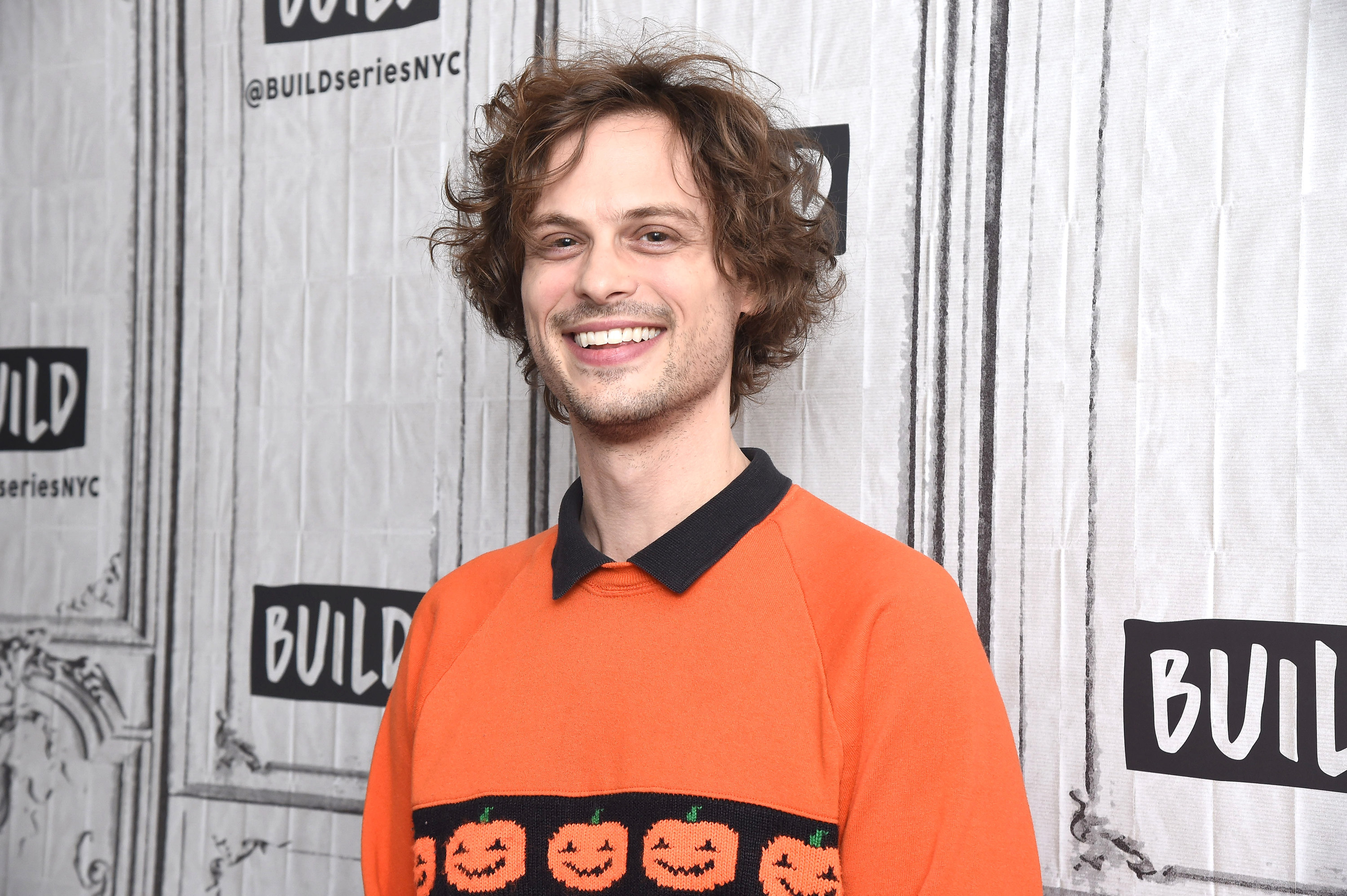 Matthew smiling and wearing an orange jack-o&#x27;-lantern shirt