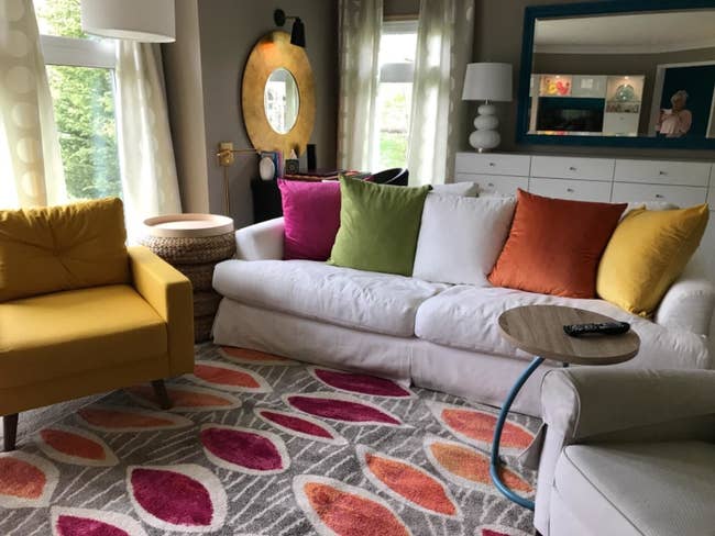 reviewer's couch with the bright and colorful solid velvet cushions