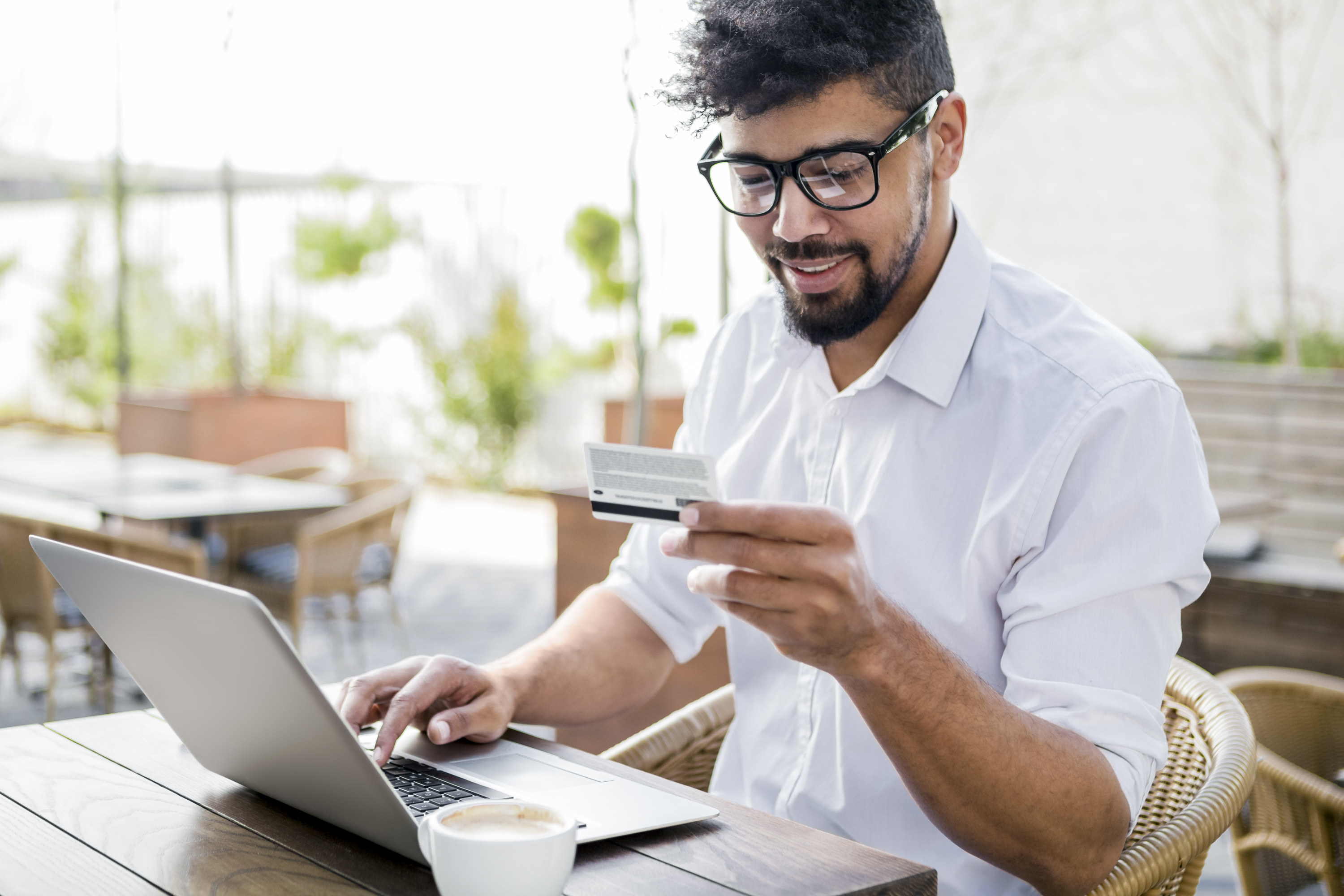 Man entering credit card number into a laptop