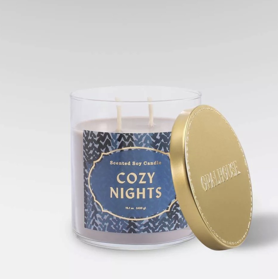 The glass candle says &quot;COZY NIGHTS&quot; and has a blue printed background with gold detailing