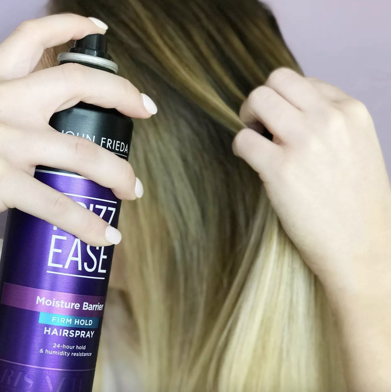 A person applying hairspray to their mane