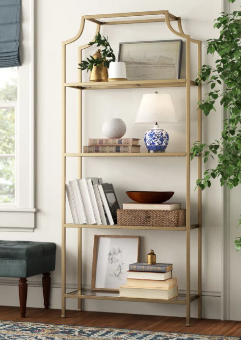 A tall book case with 4 glass shelves and open frame design with distressed metal finish