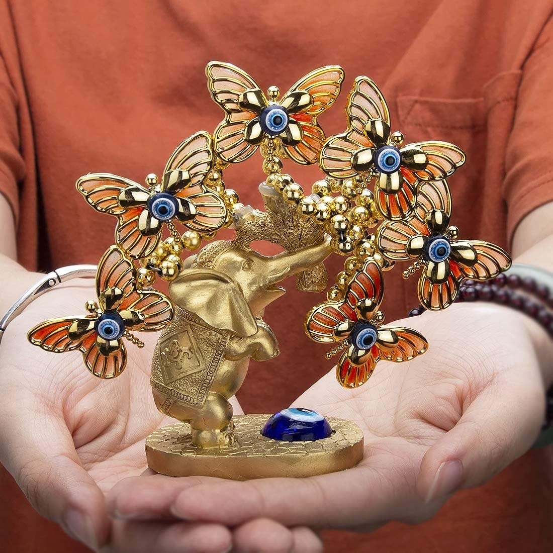Escultura de animales con ojos turcos azules y figuras de mariposa  y elefante