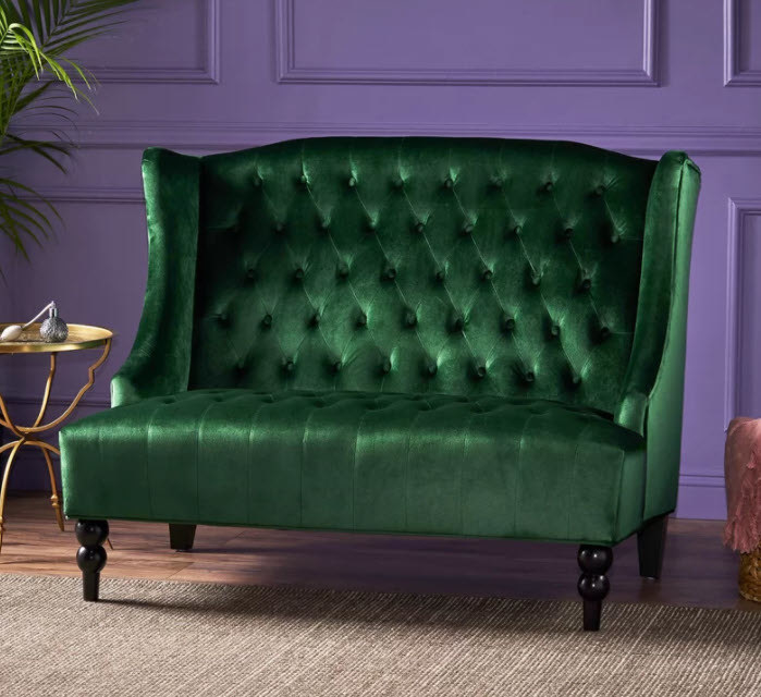 A velvet tufted wide-stretched loveseat with four dark wood peg legs
