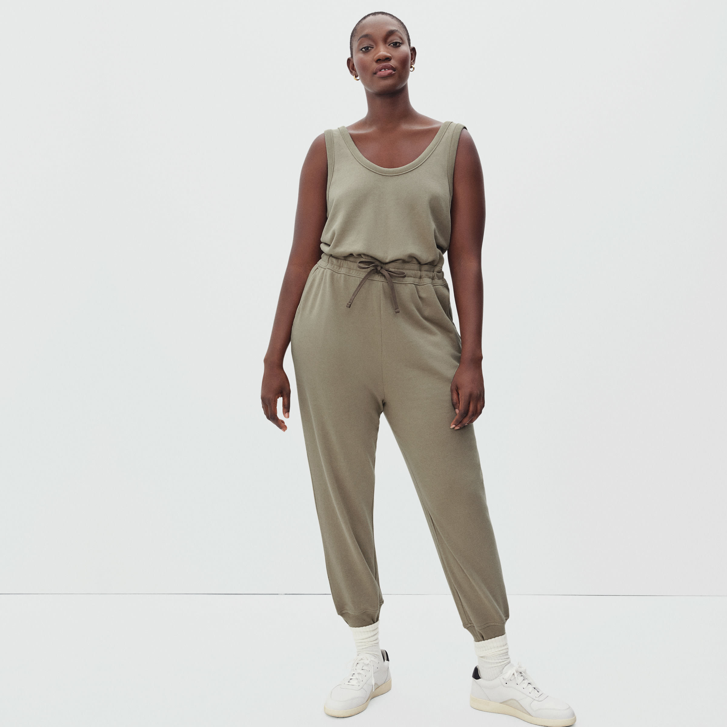 a model wears the olive jumpsuit with sneakers