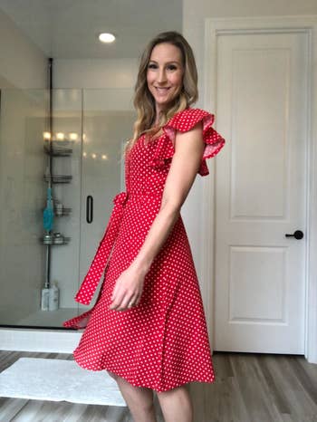 a reviewer poses in the red dress with white polka dots