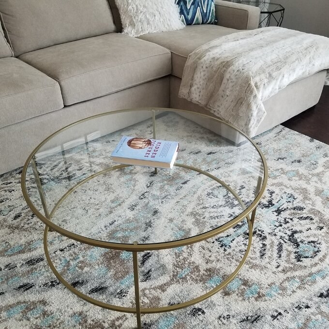 Reviewer photo showing the gold coffee table in their living room next to a sofa