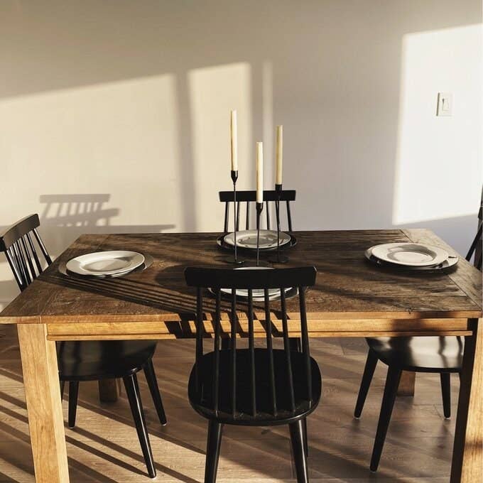 reviewer photo showing the rustic table paired with black chairs