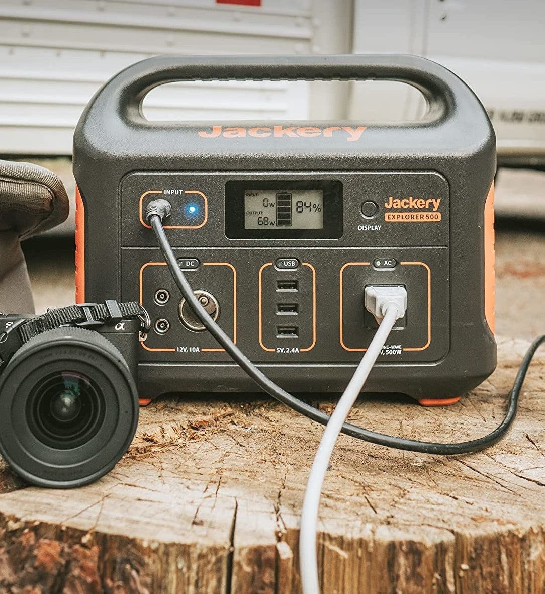 The generator on a stump with cords plugged into it