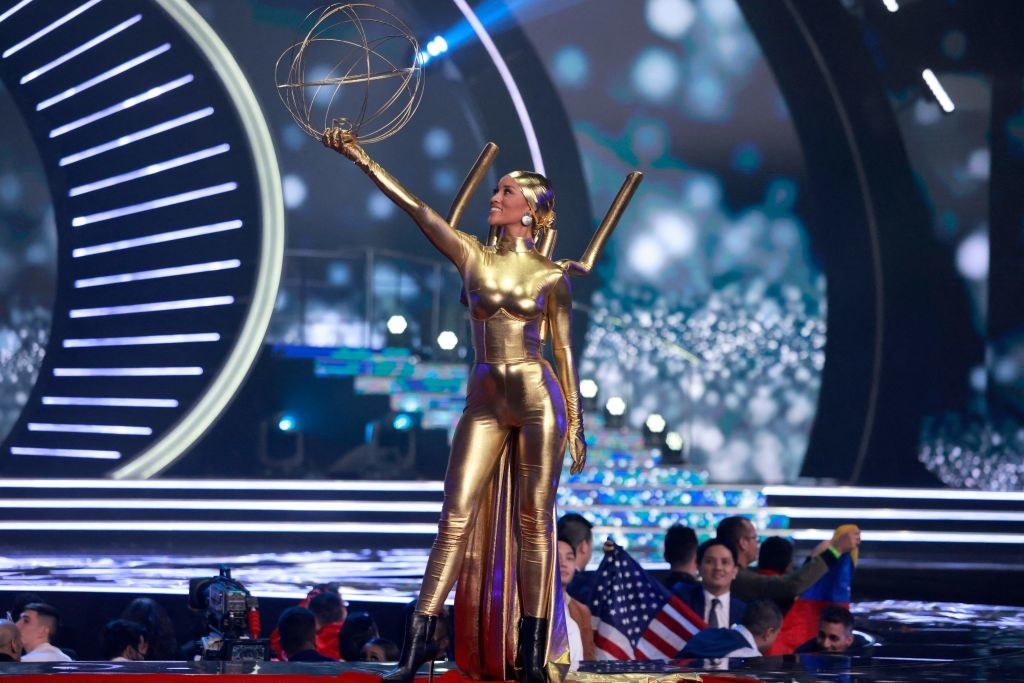 miss usa wearing gold and holding a golden sphere