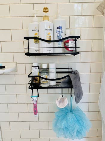 same shower caddies with large shampoo bottles and skincare product bottles suction-cupped to white tile shower wall