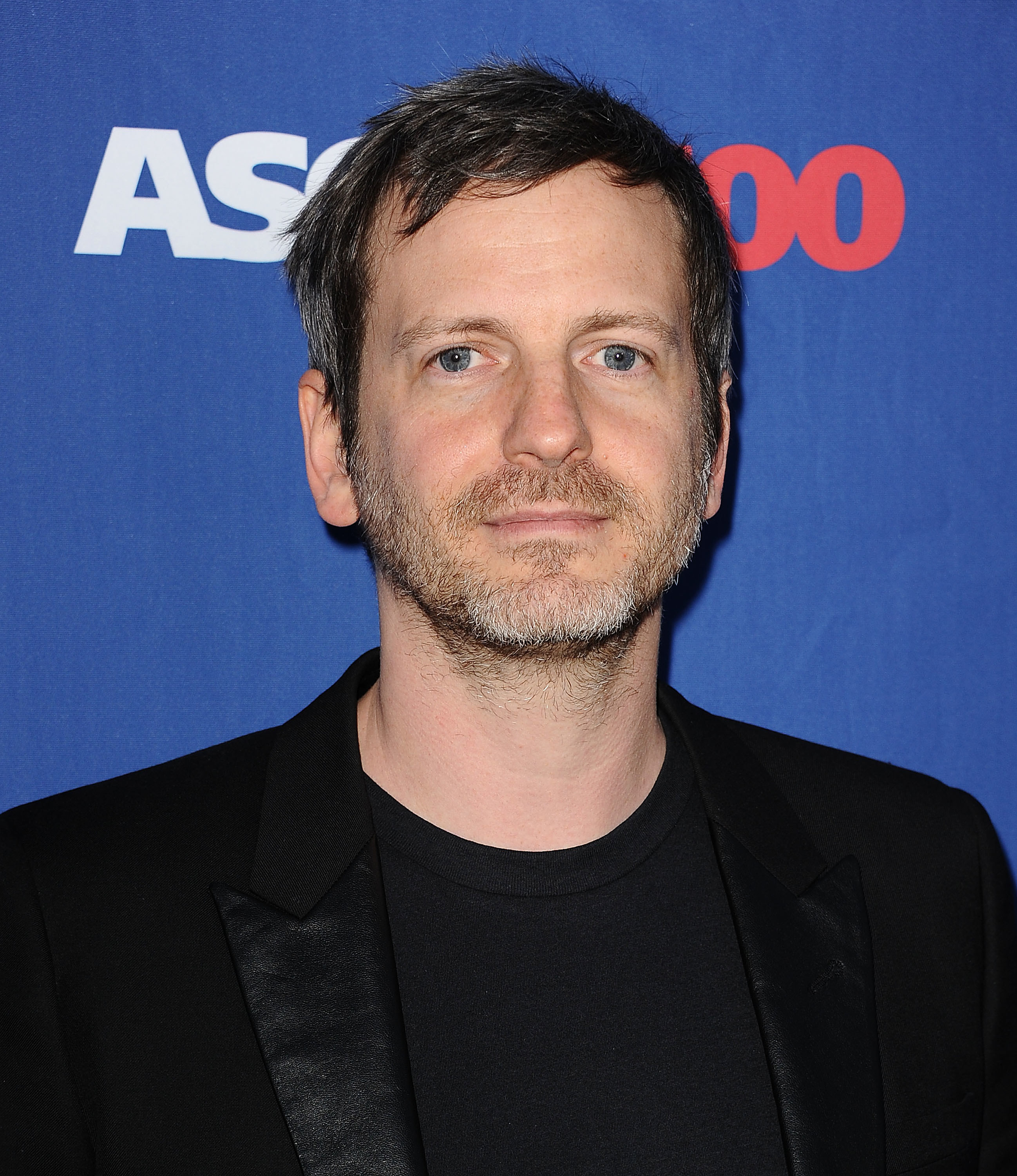 Dr. Luke looking at a camera at a red carpet event