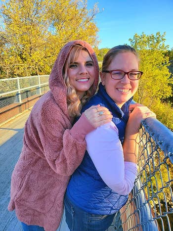 Reviewer wearing the pink hooded cardigan on a bridge