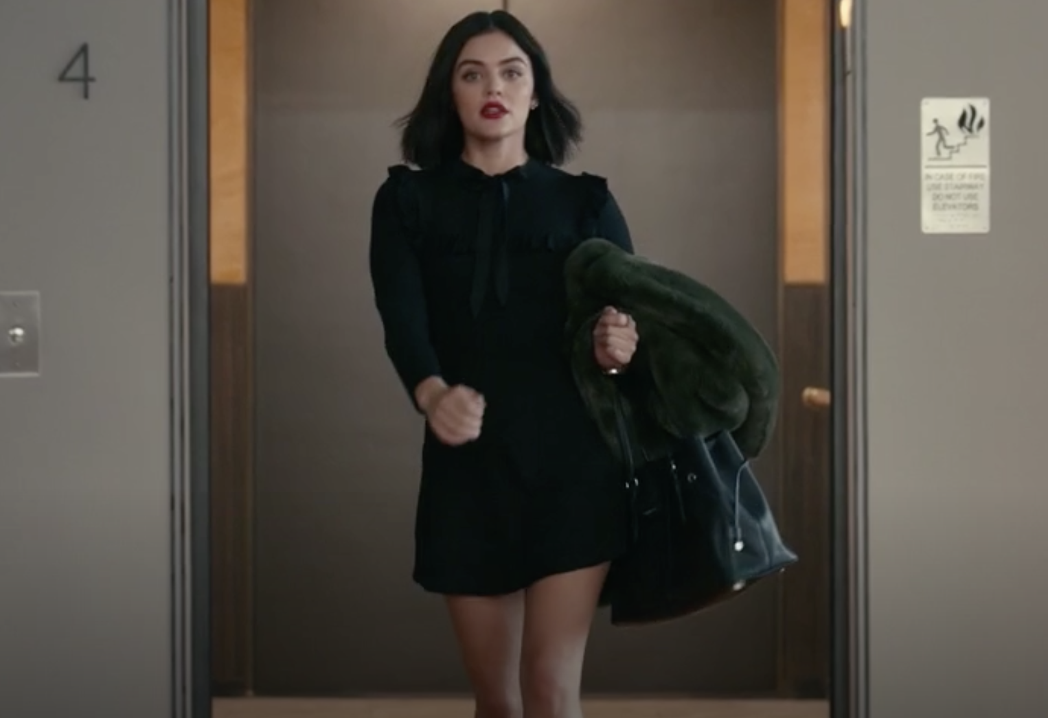 lucy in little black dress emerging from elevator