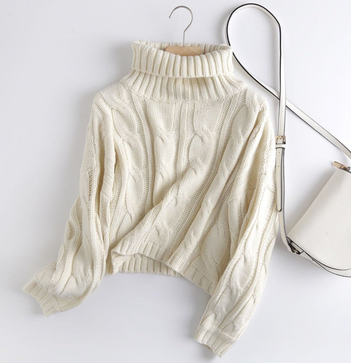 The white cropped turtleneck next to a white purse