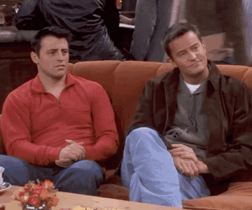 Joey Tribianni and Chandler Bing look at one another before they start to applaud someone off screen