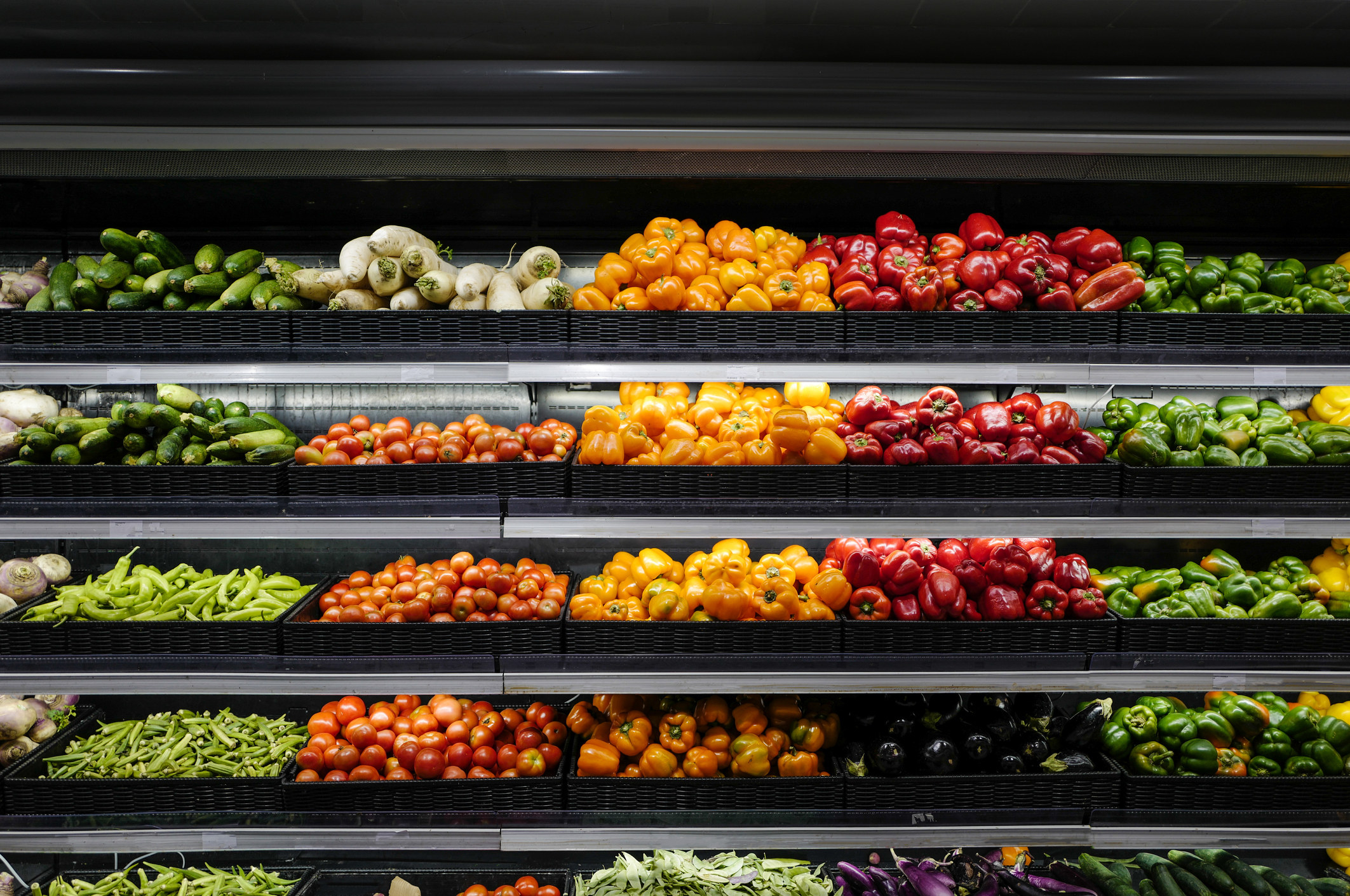 Bell peppers and zucchini and other produce on shelves