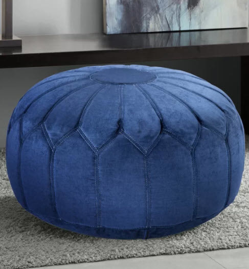 A round and wide ottoman with a polyester cover and flower-like stitching