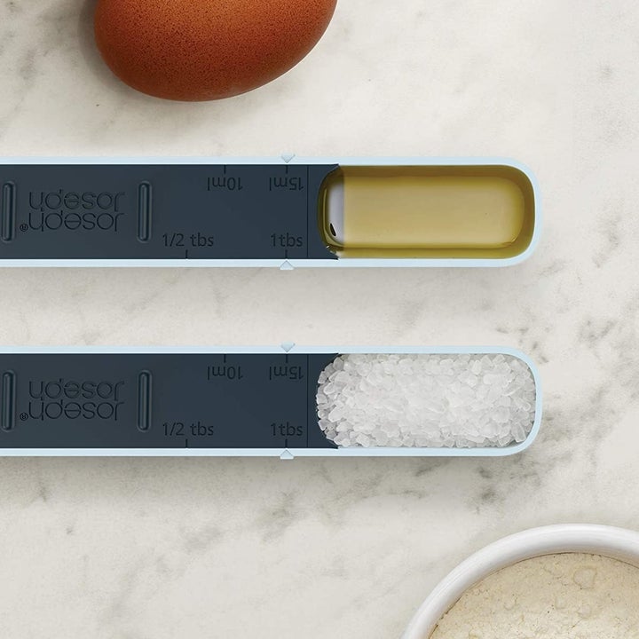 a pair of the measuring spoons with oil in one and salt in the other