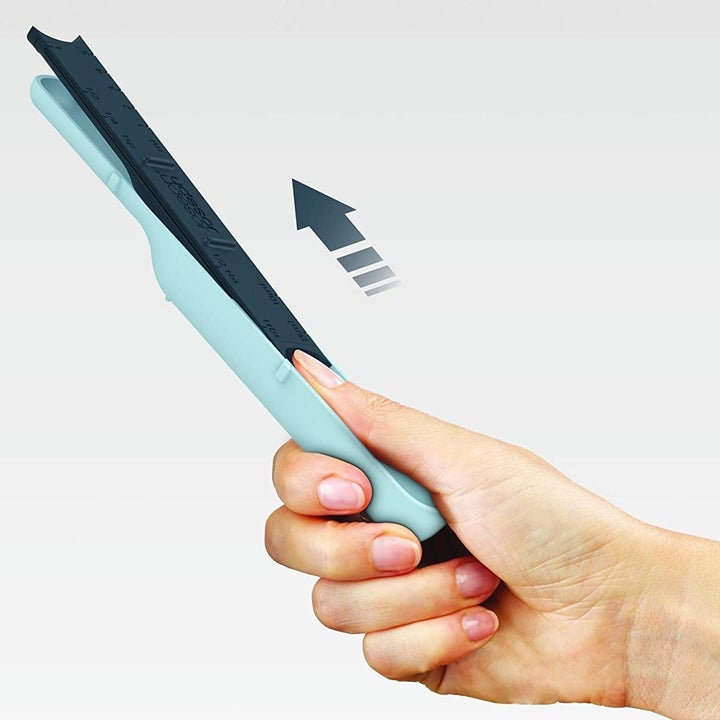a model sliding the top portion of the spoon up to adjust the measurement amount