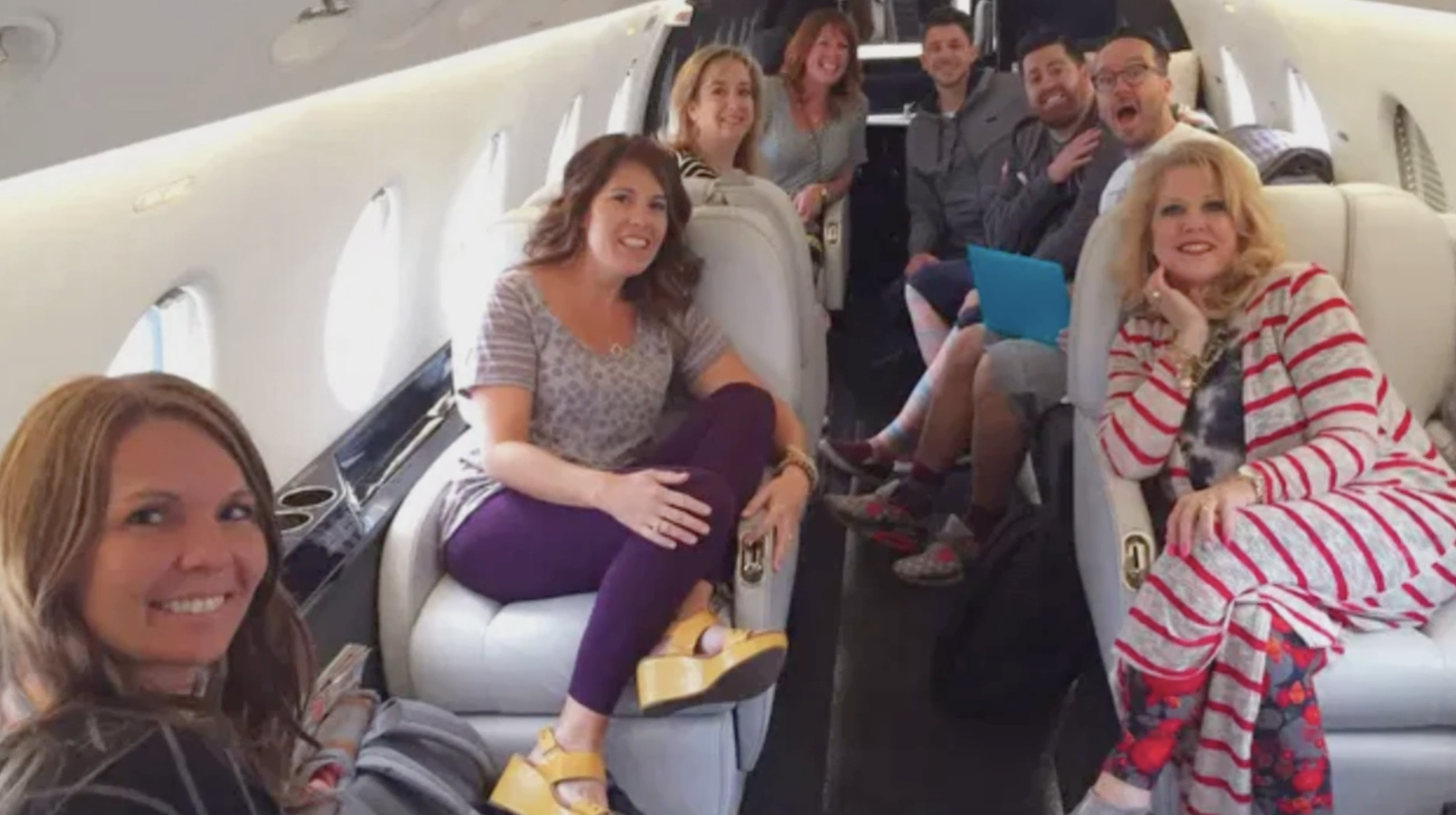 DeAnne with a group of her children/employees on a private jet